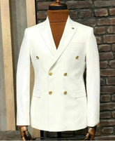 A white double-breasted blazer with gold buttons and a peak lapel worn over a brown turtleneck.