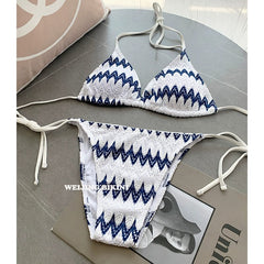 A white triangle bikini set featuring a blue chevron lace pattern and side tie closures.
