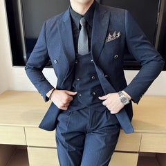A man wears a navy blue double-breasted three-piece suit with a black shirt and grey tie.