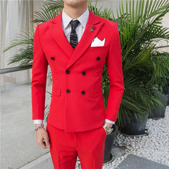A man wears a slim-fit red double-breasted suit with a white shirt and a patterned black tie.