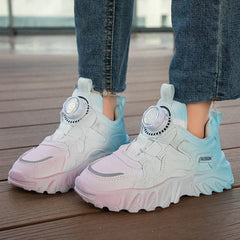 A pair of children's sneakers featuring a pink to blue gradient mesh design and a dial closure.