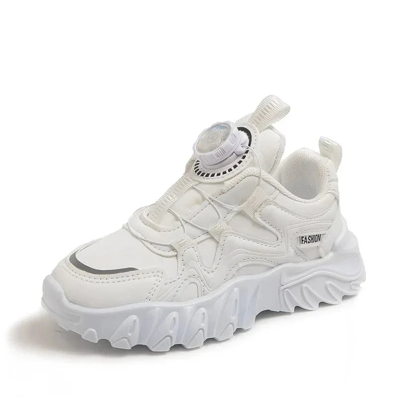 A white children's sneaker with a chunky sole, mesh upper, and a rotating dial closure system.
