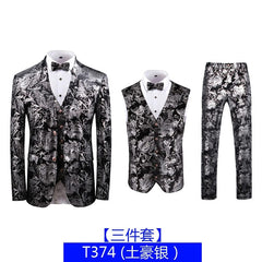 A three-piece suit featuring a black and silver floral brocade pattern, including a blazer, vest, and trousers.
