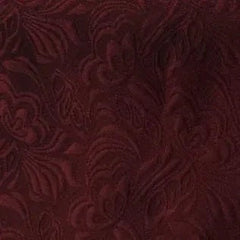 A close-up of deep burgundy fabric featuring a subtle, tone-on-tone floral damask pattern.