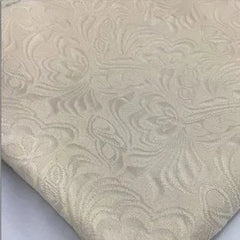 A close-up view of off-white fabric featuring an intricate tone-on-tone floral damask pattern.