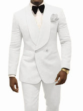 A man wears a white two-piece tuxedo with a shawl lapel, black bow tie, and matching trousers.