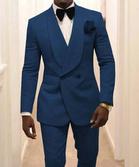 A man wears a blue two-piece tuxedo with a shawl lapel, white shirt, and black bow tie.