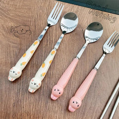 A set of stainless steel spoons and forks featuring cute cartoon rabbit handles with carrot patterns.