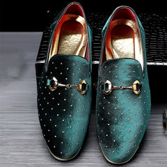 A pair of emerald green velvet loafers featuring gold horsebit hardware and rhinestone accents.