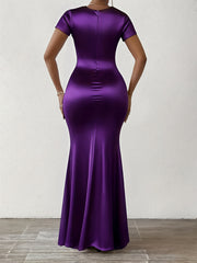 A person wears a floor-length, short-sleeved purple satin bodycon dress from the back.