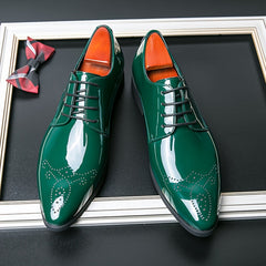 A pair of glossy green pointed-toe lace-up dress shoes with decorative brogue detailing.