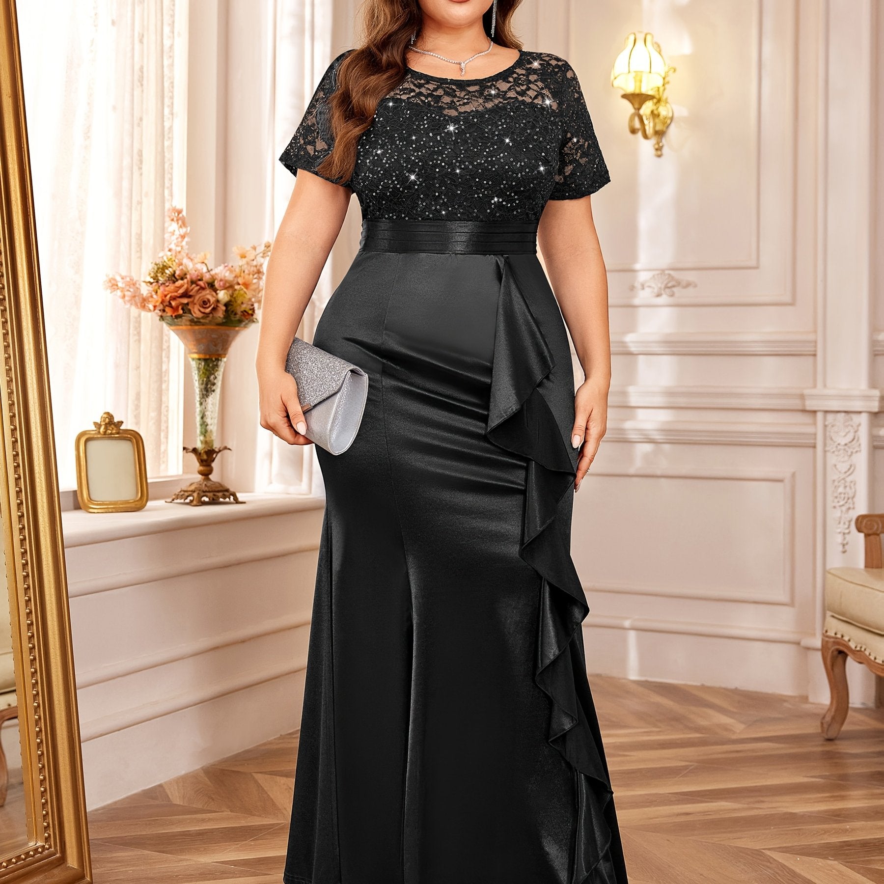 A plus size black mermaid dress with a sequined lace bodice, short sleeves, and ruffled side.