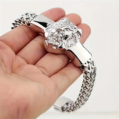 A silver stainless steel bracelet featuring a detailed lion head centerpiece and a braided chain.