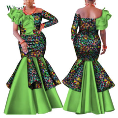 A woman models a colorful patterned African dress with a lime green ruffle and flared skirt.