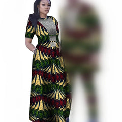 A woman wears a long, short-sleeved African print dress with a silver sequined bodice.