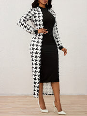 A woman wears a black knee-length dress paired with a long-sleeved houndstooth cape.