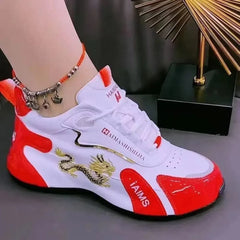 A white and red lace-up sneaker featuring a gold dragon embroidery on the side.