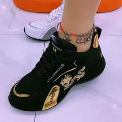 A black lace-up sneaker featuring gold dragon embroidery and metallic gold accents.