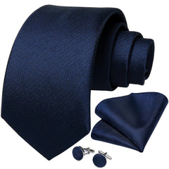 A navy blue silk necktie set including a matching pocket square and a pair of cufflinks.