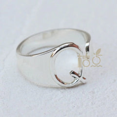 A silver-plated open ring featuring a prominent letter Q design.