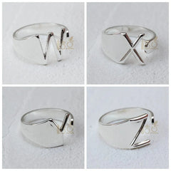 Four silver-plated open rings featuring the letters W, X, V, and Z on a white background.