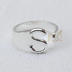 A silver-plated open ring featuring a prominent letter S design.