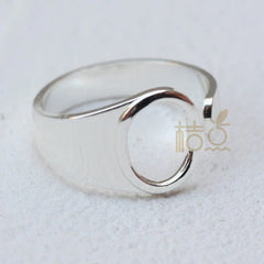 A silver-plated open ring featuring a circular design on a plain band.