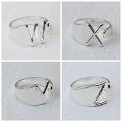 Four silver-plated open rings featuring the letters W, X, V, and Z on a white background.