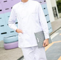 A person wearing a white long-sleeved medical scrub top with a button-up front and chest pocket.