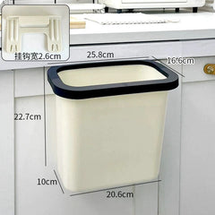 A cream-colored, wall-mounted plastic kitchen trash can with a black rim and hanging bracket.