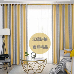 Modern yellow and gray striped blackout curtains with grommet tops hanging in a living room.