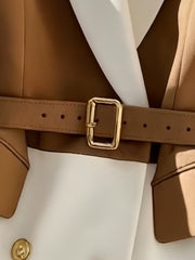 A tan and white color-block vest featuring a matching belt with a gold buckle and gold buttons.