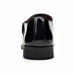 A rear view of a black patent leather men's dress shoe with a buckle and a solid block heel.