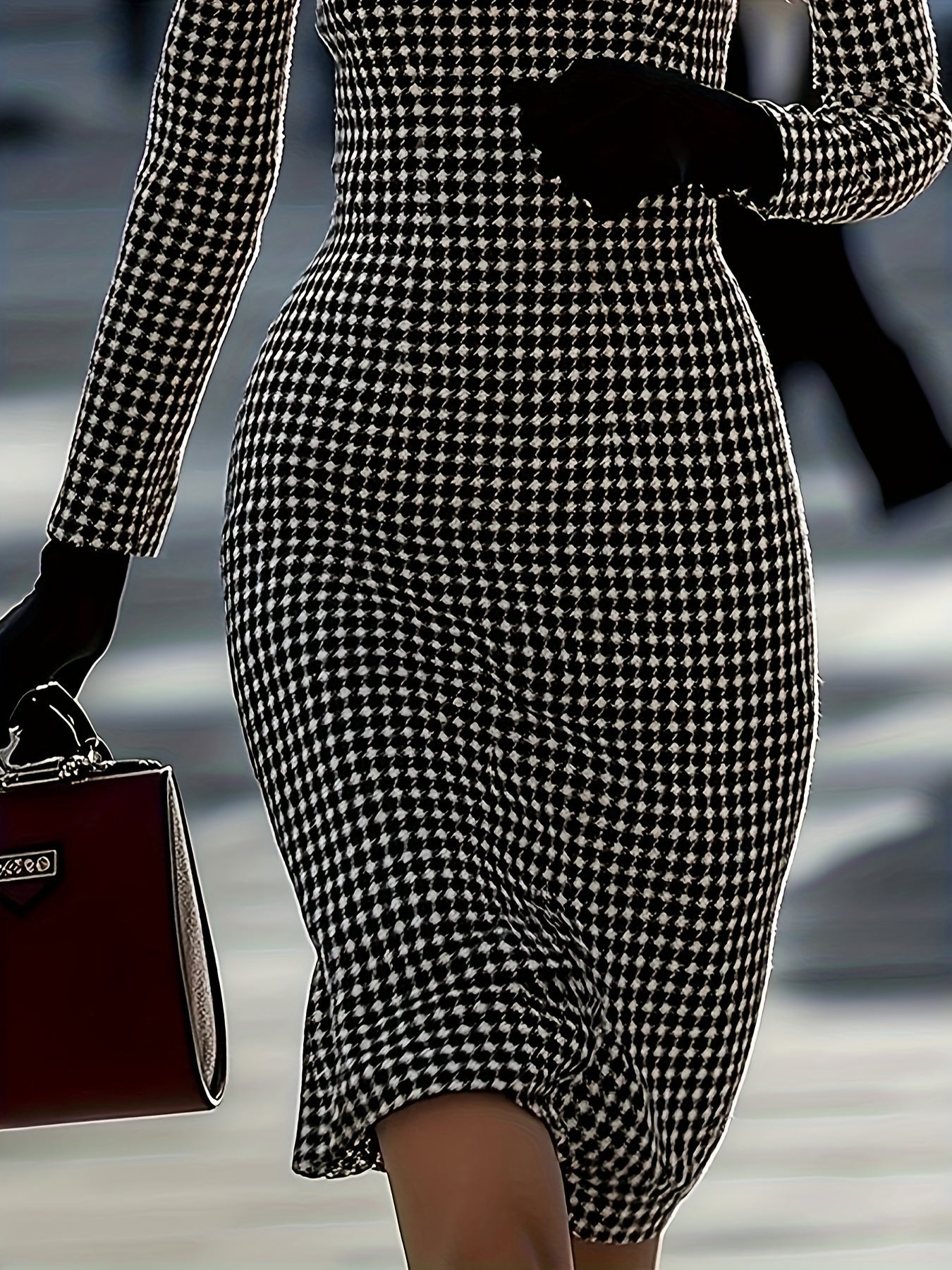 A woman wears a fitted, long-sleeve black and white houndstooth dress with a crew neckline.