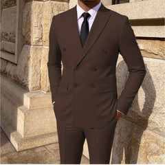 A man wears a solid brown double-breasted suit with a white shirt and black tie.