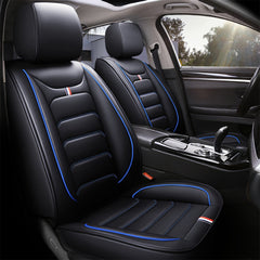 Black faux leather car seat covers with blue piping and small red, white, and blue accents.