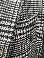 A close-up view of a black and white houndstooth woven fabric on a men's blazer.