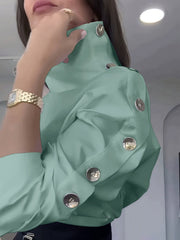 A mint green high-neck blouse featuring a row of silver buttons along the shoulder and sleeve.