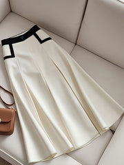 A white A-line skirt featuring a black color-blocked waistband and side accents.