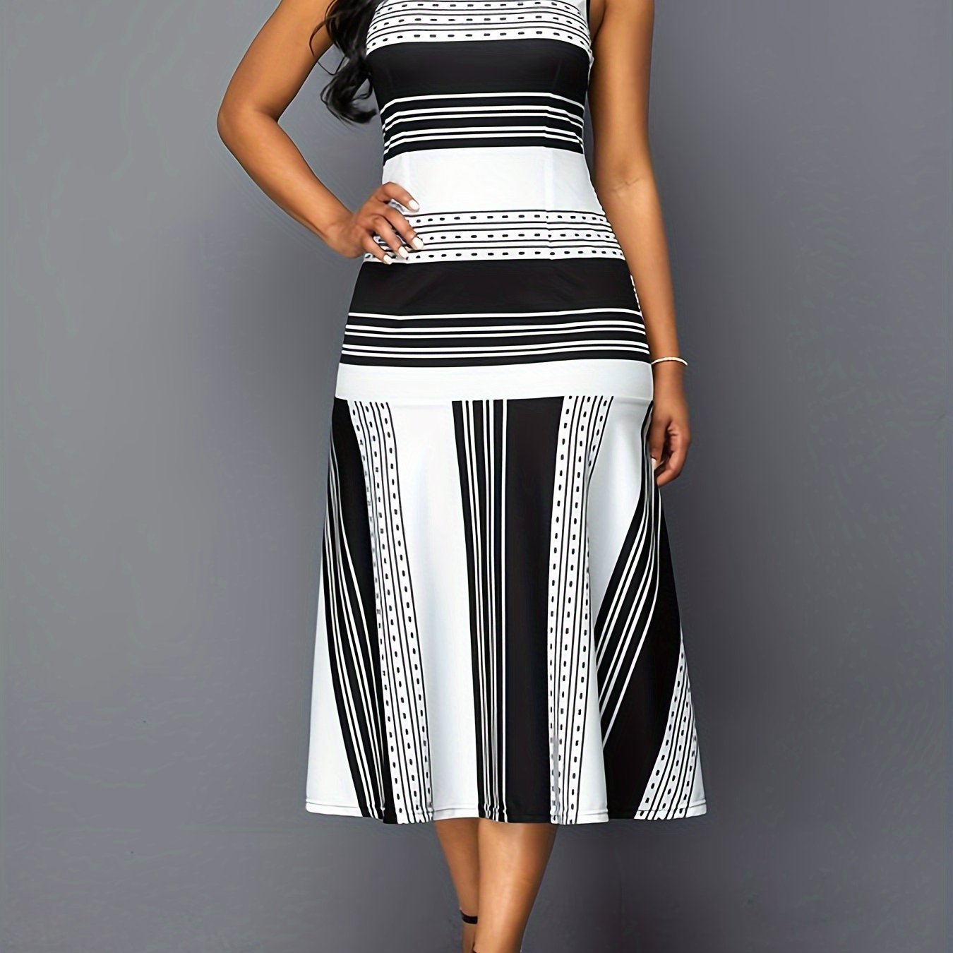 A sleeveless midi dress featuring a black and white striped and dotted patchwork pattern.