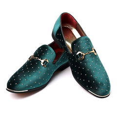 A pair of emerald green velvet loafers featuring gold horsebit hardware and rhinestone accents.