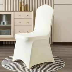 A white, one-piece elastic chair cover fits snugly over a chair, shown in a neutral room setting.