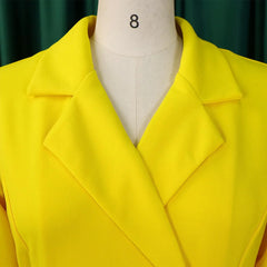 A bright yellow double-breasted blazer dress featuring a notched collar on a mannequin.