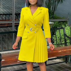A woman wears a bright yellow double-breasted blazer dress with a notched collar and pleated skirt.