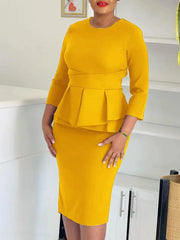 A woman wears a mustard yellow midi-length sheath dress with three-quarter sleeves and a peplum.