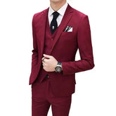 A man wears a slim-fit burgundy three-piece suit consisting of a blazer, vest, and matching pants.