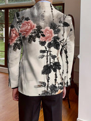 A man wears a long-sleeve blazer featuring a black and white ink-wash floral print.