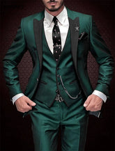 A man wears a dark green three-piece suit with a black lapel, white shirt, and skull-patterned tie.