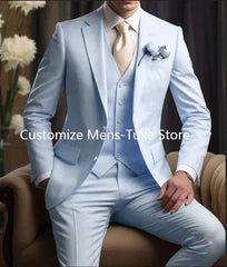 A man wearing a light blue slim-fit three-piece suit with a white shirt and cream tie.