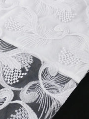 Close-up of a white lace dress featuring intricate feather-like embroidery on a sheer mesh overlay.